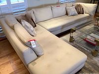 Front-left angle view of the full L-shaped cream sectional with pillows