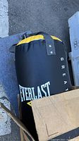Heavy bag round shape black with yellow on top with Everlast logo visible.