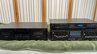 Front view of Onkyo TA-RW255 cassette deck alongside Fisher EQ-276 graphic equalizer showing controls and labels on black finish.