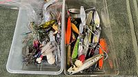 Plastic container with tangled fishing lures including soft plastics and spoons