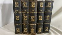 Five vintage hardcover books titled 'The Mentor' with serial numbers 1-24, 25-48, 49-72, 73-96, and 97-120 on their dark spines with gold text and decorative illustrations.
