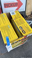 Photo of two yellow Duraflame boxes stacked, one opened showing fire logs inside, the other box sealed.