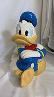 Front and side view of vintage Disney Donald Duck cookie jar showing detailed features and paint work.