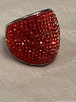 Ring showing bright red Swarovski crystals densely set on a polished sterling silver band.