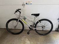 Full side view of silver Raleigh Tomahawk mountain bike showing frame, tires, seat, handlebar, and pedals.