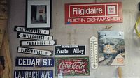 Full view of advertising and street signs, thermometer, framed photo including Coca-Cola and Frigidaire signs