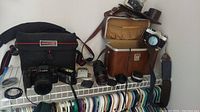 Shelf with cameras, lenses, cases, and accessories displayed together showing the full lot contents.