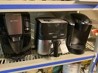 Three small kitchen appliances on shelf: Mr. Coffee coffee maker, Cooks air fryer, and Keurig coffee maker.