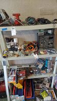 Full view of plastic shelving unit with assorted tools and hardware items displayed on shelves, showing the variety of contents and containers.