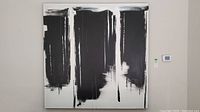 Full view of large black and white abstract canvas painting hung on wall, showing overall composition and size relative to surrounding wall space.