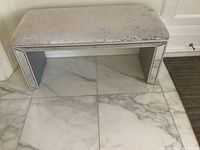 Front view of the bench showing the plush textured top and mirrored legs with decorative mirrored accents on the edges.