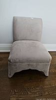 Front view of the armless accent chair showing cushioned seat and backrest in light gray upholstery.