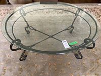 Top view of the oval bevelled glass top coffee table showing glass surface and wrought iron base beneath