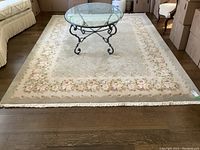 Full view of the wool area rug laid out on hardwood floor showing overall pattern and condition