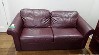 Frontal view of Chesterfield style brown leather sofa bed.