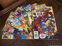8 Marvel Spider-Man comic books fanned out showing front covers with various characters and comic book logos.