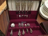 Overview of flatware set arranged in the open red velvet-lined wooden canteen