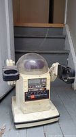 Front view of Tomy robot cassette player with clear dome head, buttons, cassette player controls, and articulated arms.