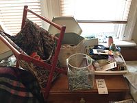 Wooden sewing basket with fabric liner, clear container filled with pins, scissors, and open box of sewing notions