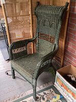 Side view of green wicker chair showing woven details and slight wear.