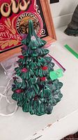 Front angle of green ceramic Christmas tree with colored bulbs mounted in holes. Shows shape and placement of bulbs.