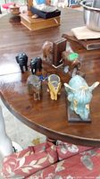 Overview photo showing the elephant figurines and bookends on a wooden table with other household items in the background