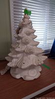 Full view of 19 inch tall frosted ceramic Christmas tree showing sculpted detail and holes for lights.