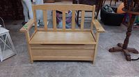 Front view of the wooden child's deacons bench showing seat, armrests and slat back design.