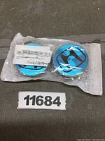Two new Honda center caps in original packaging showing the blue background and black Honda logo.