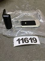 Photo of NEEWER camera grip showing angled view of the grip handle and frame while packaged in transparent plastic.