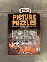 Front cover of the picture puzzles book showing the title and themed illustration of a detective examining differences.