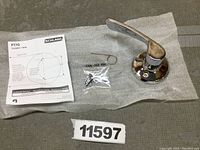 Photo showing Schlage F170 dummy trim lever with mounting hardware and instruction manual on protective cloth.