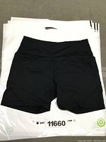 Black SHEIN yoga shorts laid flat with white background plastic bag beneath.