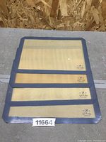 Four Zulay Kitchen silicone baking mats stacked, showing the light gray border and beige silicone mesh surface with logo.