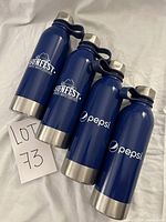 Four blue stainless steel water bottles, two with Sunfest logos and two with Pepsi logos, showing front branding and caps.