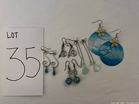 Full lot of 5 pairs of earrings laid out together showing variety and condition