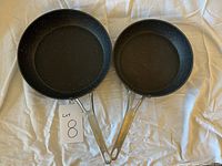 Two Heritage Rock frying pans laying flat showing the speckled non-stick surfaces and metal handles.