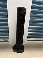 Full front view of black Sunbeam tower fan showing vertical grille and octagonal base.