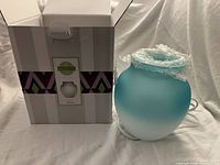 Scentsy Serene wax warmer out of box, wrapped in bubble wrap, with original packaging box in background