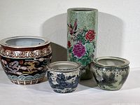 Overview of the set including the tall green vase, large black pot with dragons, and two smaller pots showing different floral and landscape scenes.