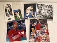 Overview of all five autographed baseball player photos in 8x10 sleeves, showing various players and poses.