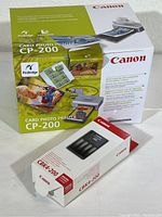 Full view of Canon Card Photo Printer CP-200 box adjacent to CBK4-200 battery and charger kit box on a white surface.