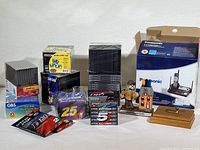Wide view of all items including phone box, cassette tapes, jewel case packs, and desktop decorative items.