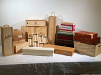 Full view of the assorted empty wooden boxes arranged together on a table, showcasing different sizes, shapes and styles.