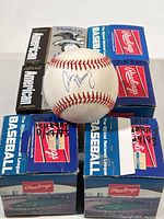 View of six Rawlings official National League baseball boxes with autographed baseballs displayed on top, signed by various MLB players including Calvin Murray and Shawn Hillagaz.