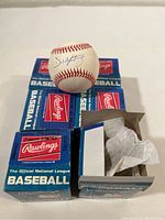 Six Rawlings Official National League Baseballs with original boxes, one box open showing tissue paper inside.