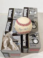 Photo showing six Rawlings National League and American League official baseball boxes with handwritten labels identifying players Bryan Hickerson, Steve Karsay, Mike Norris, Will Van L, Bob Brent, Juan Marichal. One baseball signed by Bryan Hickerson is visible with a blue ink signature.