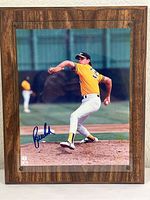 Photo of signed Bob Welch pitching image mounted on wood plaque with OCR showing signature on photo.