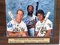 Full view of the autographed photo plaque showing the three players, their signatures, and the engraved brass plate