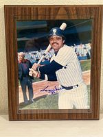 Full view of signed, mounted photo of Reggie Jackson in New York Yankees uniform on a wooden plaque.